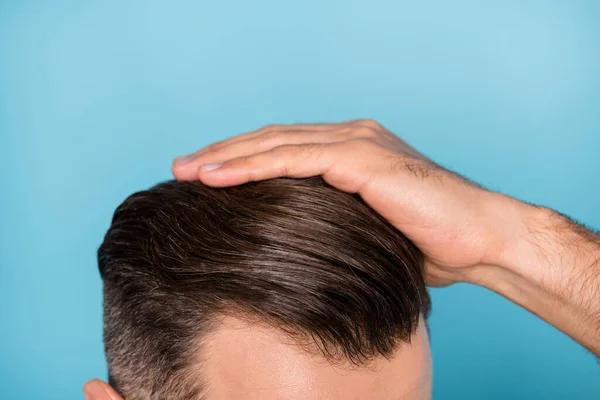 Gewassen foto van jonge knappe man vaststelling van zijn kapsel zijdezacht gezond haar geïsoleerd op blauwe kleur achtergrond — Stockfoto