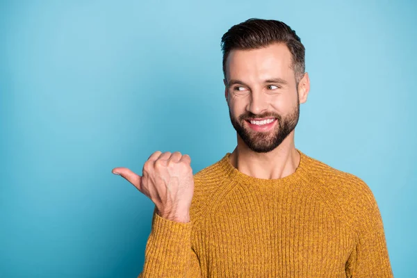 Retrato de buen chico alegre y confiado usando suéter de punto demostrando espacio de copia de anuncio aislado sobre fondo de color azul brillante — Foto de Stock