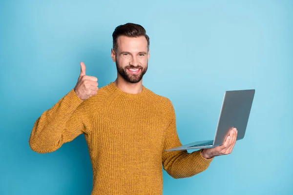 在明亮的蓝色背景下，用笔记本电脑展示漂亮迷人、开朗的男人形象，展示大拇指大拇指的建议广告 — 图库照片