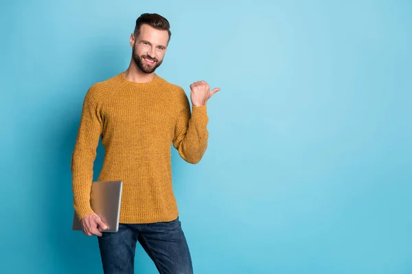 Portret van aantrekkelijke vrolijke bekwame man dragen laptop tonen kopieerruimte advertentie geïsoleerd over helder blauwe kleur achtergrond — Stockfoto