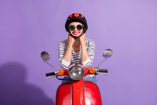 Portret szczęśliwej kobiety jeźdźca noszącej kask czerwona szminka sunglass siedzi na motocyklu uśmiechając się odizolowany na jasnym fioletowym tle — Zdjęcie stockowe