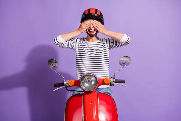 Zdjęcie funky dziewczyna jeździć na motocyklu palmy zamknij oczy otwarte usta nosić kask w paski koszula odizolowany fioletowy kolor tło — Zdjęcie stockowe