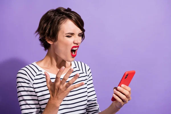 Perfil foto de irritado irritado menina segurar telefone olhar tela gritar usar camisa listrada isolado cor violeta fundo — Fotografia de Stock