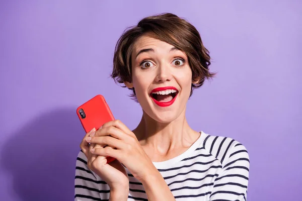 兴奋的疯狂女孩拿着电话摄像头张开嘴穿着条纹衬衫孤立的紫罗兰色背景照片 — 图库照片