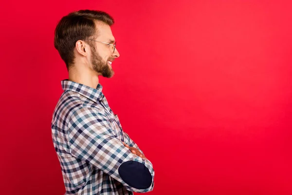 Foto de encantador caballero bonito vestido a cuadros camisa gafas manos dobladas buscando espacio vacío aislado color rojo fondo — Foto de Stock