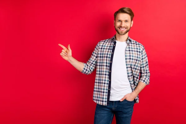 Foto de hombre joven feliz sonrisa positiva dedo dedo vacío espacio anuncio seleccionar sugerir promo aislado sobre fondo de color rojo — Foto de Stock