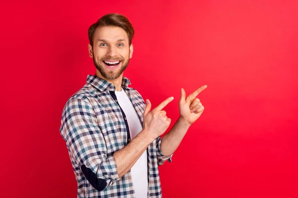 Profil côté photo de jeune homme heureux sourire positif pointe doigts espace vide ad promo conseils isolés sur fond de couleur rouge — Photo