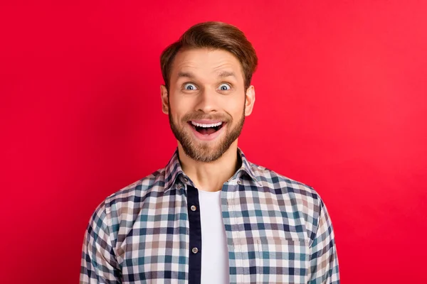 Φωτογραφία του νεαρού ενθουσιασμένοι όμορφος άντρας χαρούμενος θετικό χαμόγελο έκπληκτος πώληση ειδήσεων απομονώνονται πάνω από το κόκκινο φόντο χρώμα — Φωτογραφία Αρχείου
