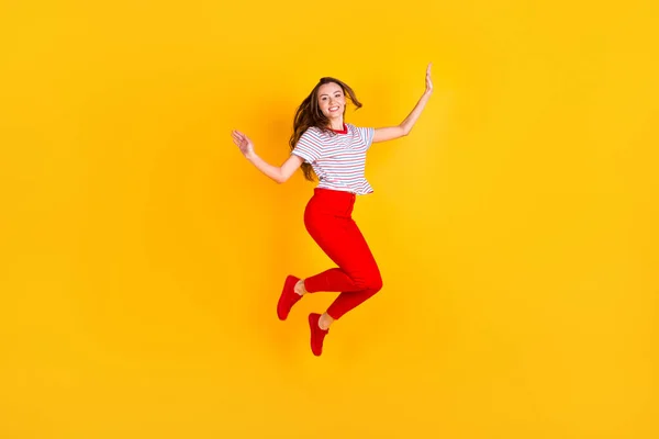 Φωτογραφία από χαριτωμένο αξιολάτρευτο άλμα κυρία έχουν τη διασκέδαση φορούν ριγέ πουκάμισο κόκκινο παντελόνι υποδήματα απομονωμένο κίτρινο χρώμα φόντο — Φωτογραφία Αρχείου