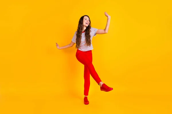 Foto de tamaño completo de la joven excitada feliz sonrisa positiva divertirse danza mirada espacio vacío aislado sobre fondo de color amarillo —  Fotos de Stock