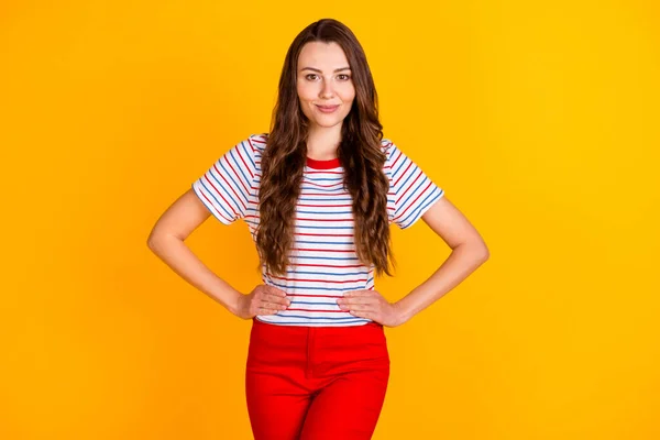 Retrato de conteúdo alegre atraente feminino tímido mãos menina em quadris isolados sobre vibrante cor amarela fundo — Fotografia de Stock