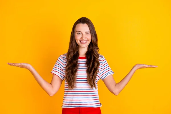 Retrato de chica alegre atractiva sosteniendo en palmeras copia espacio vacío ofrecen solución de guiño aislado sobre fondo de color amarillo brillante — Foto de Stock