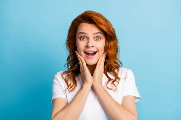 Photo portrait of shocked woman touching face cheeks with two hands isolated on pastel blue colored background