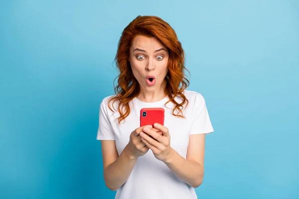Foto portret van geschokte vrouw met telefoon in twee handen geïsoleerd op pastel blauw gekleurde achtergrond — Stockfoto