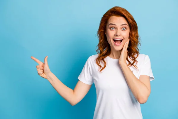 Foto ritratto di ragazza scioccata toccare faccia guancia con mano puntando il dito verso lo spazio vuoto isolato su sfondo di colore blu pastello — Foto Stock