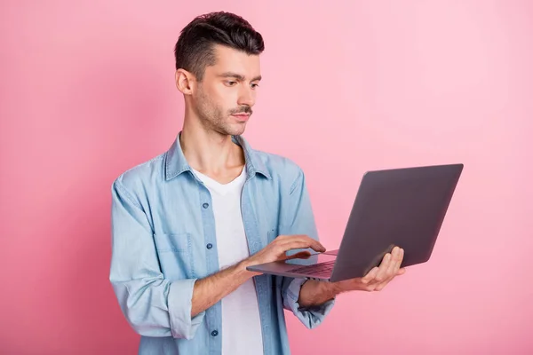 Photo portrait young entrepreneur working computer serious confident reading information isolated pastel pink color background — Stock Photo, Image