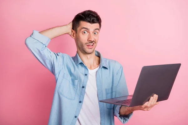 Photo portrait of grimacing student working laptop unsure uncertain wearing casual shirt isolated pastel pink color background — Stock Photo, Image