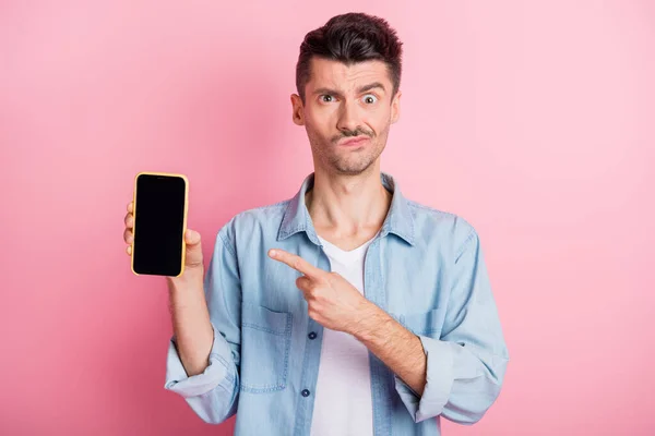 Foto de hombre morena joven molesto dedo índice pantalla teléfono retroalimentación aislado sobre fondo de color rosa — Foto de Stock