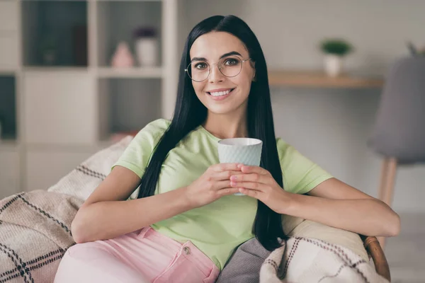 Närbild porträtt av charmiga glad lugn långhårig flicka sitter på mysiga rutig pärm dricka kakao i ljus interiör rum — Stockfoto