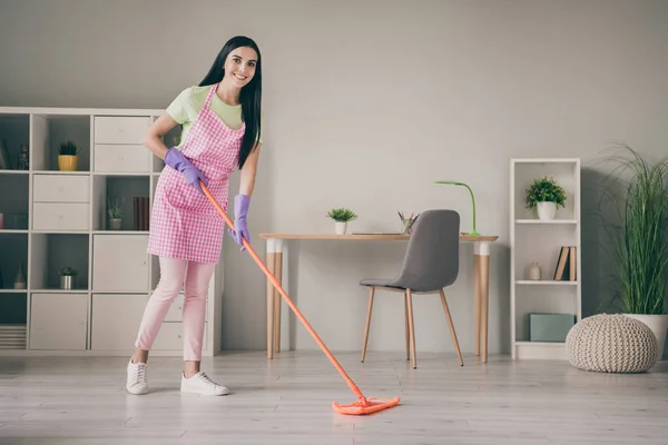 Ganzkörpergröße Ansicht von ziemlich fröhlich langhaarige Mädchen Reinigung Boden ordentlich Aufräumservice Hygiene im hellen Innenraum — Stockfoto