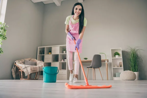 Comprimento total do corpo tamanho vista de muito glamourosa alegre menina de cabelos compridos limpeza do chão dever na luz interior sala de estar — Fotografia de Stock