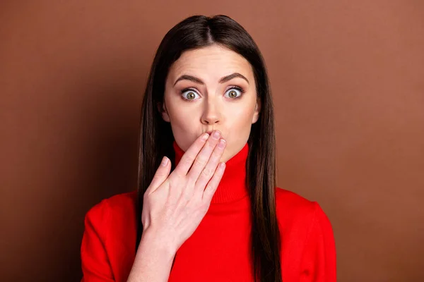 Foto av skyldig chockad ung dam bära röd pullover arm täcka läppar isolerad brun färg bakgrund — Stockfoto