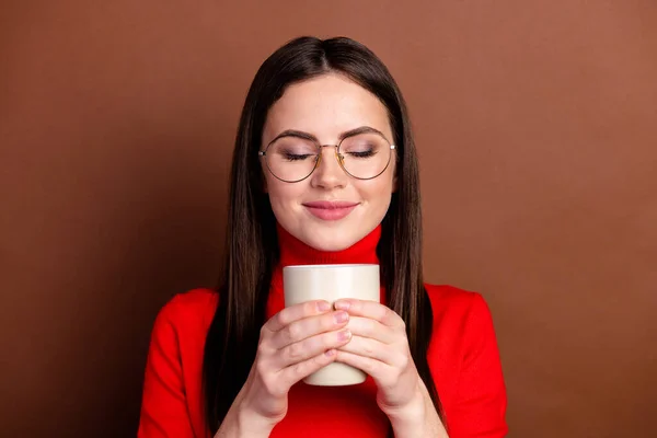 Retrato de positivo menina olhos fechados braços segurar café cheirando isolado no fundo de cor marrom — Fotografia de Stock
