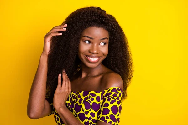 Portret van aantrekkelijke vrolijke dromerige meisje aanraken zijdezacht glad schoon haar geïsoleerd over helder gele kleur achtergrond — Stockfoto