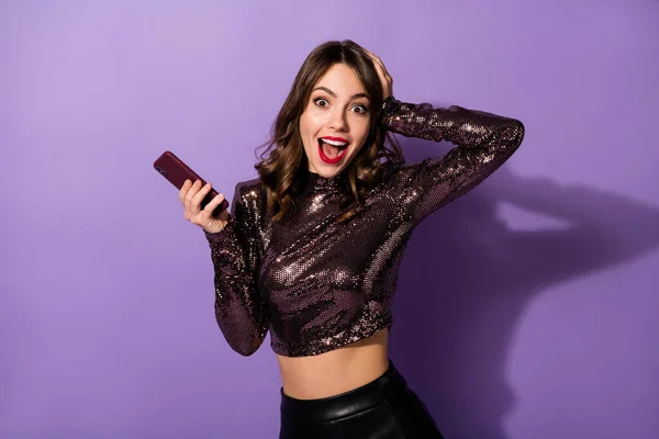 Retrato de encantadora chica alegre asombrada usando dispositivo que tiene retroalimentación positiva divertida aislada sobre fondo de color violeta brillante —  Fotos de Stock