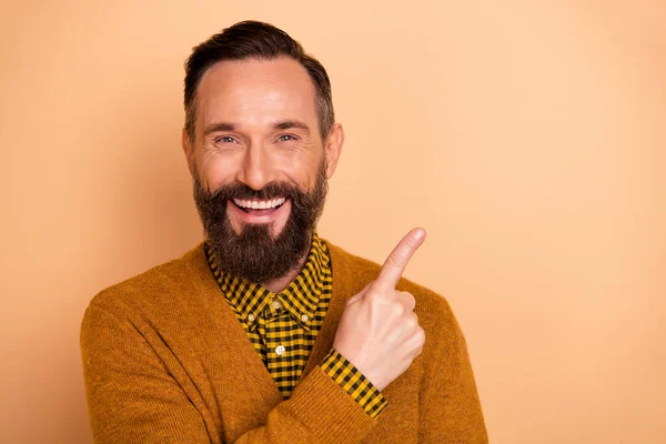 stock image Portrait of satisfied handsome man toothy smile indicate finger empty space isolated on beige color background