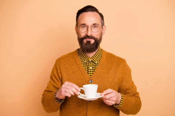 Foto de hombre maduro sostiene la taza con espresso aislado sobre fondo de color beige — Foto de Stock