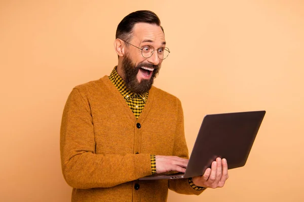 Foto di uomo maturo stupito uso laptop urlare sconti internet indossare maglione isolato su sfondo di colore beige — Foto Stock