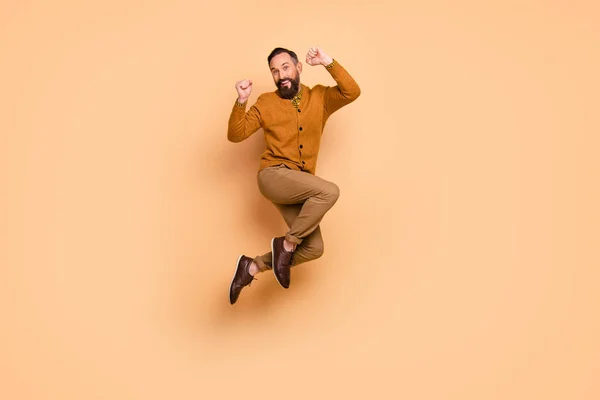 Full length photo of delighted handsome guy fists up toothy smile celebrate isolated on beige color background — Stock Photo, Image