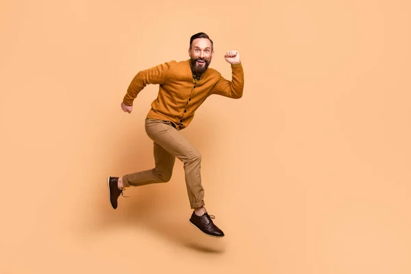 Ganzkörperprofil Foto von fröhlich gutaussehenden Kerl zahmes Lächeln Blick Kamera isoliert auf beige Farbhintergrund — Stockfoto