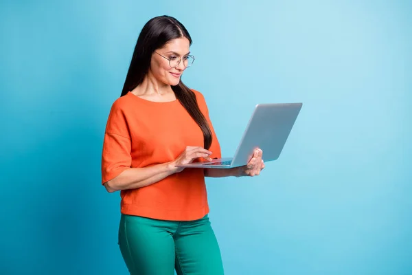 Foto av charmiga positiva dam händer hålla bärbar dator ser skärmen isolerad på pastell blå färg bakgrund — Stockfoto