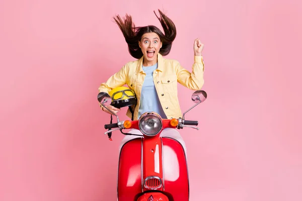 Foto van jong opgewonden gelukkig aantrekkelijk meisje vrouw houden gele helm rijden rode motor vliegen haar geïsoleerd op roze kleur achtergrond — Stockfoto