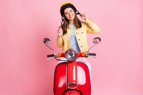 Foto av unga glada positiva leende flicka kvinna kvinnlig bära gul hjälm rida röd motorcykel isolerad på rosa färg bakgrund — Stockfoto