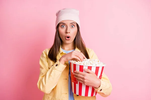Foto av vackra dam armar som håller popcorn stirrar förvirrad öppen mun isolerad på rosa färg bakgrund — Stockfoto
