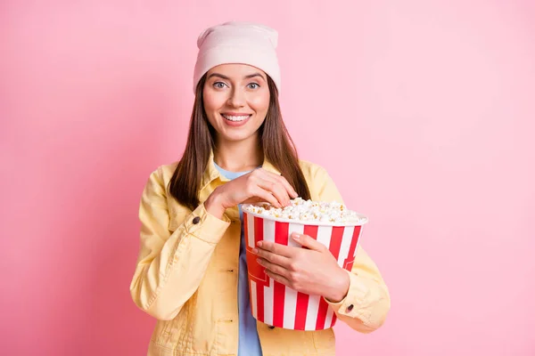 Porträtt av charmig person kylning ha kul äta popcorn bära mössa isolerad på pastell rosa färg bakgrund — Stockfoto