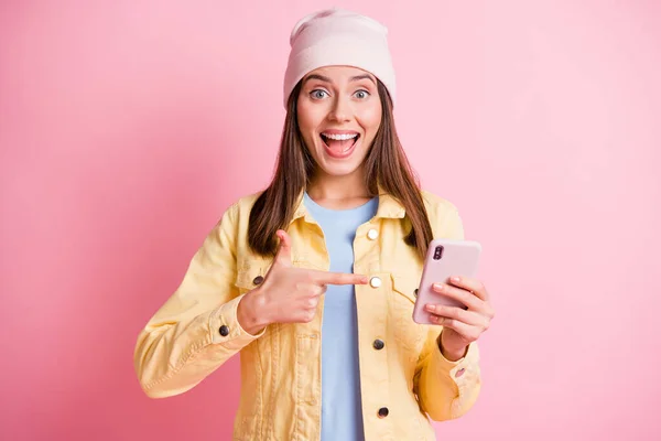 Foto de bela menina de cabelos castanhos segurar ponto telefone novidade usar chapéu rosa isolado no fundo cor-de-rosa — Fotografia de Stock