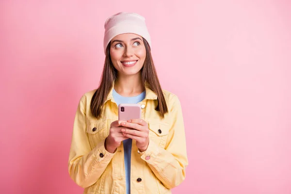 Photo of happy dreamy young woman look empty hold phone space imagine comment isolated on pastel pink color background — Stock Photo, Image