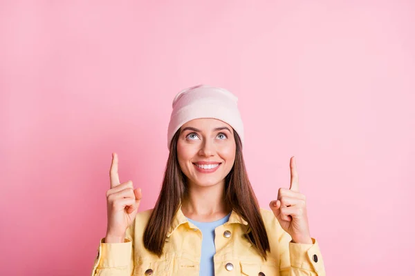Foto de atractiva chica de pelo castaño usar chaqueta amarilla punto mirada espacio vacío por encima de descuento aislado en el fondo de color rosa —  Fotos de Stock