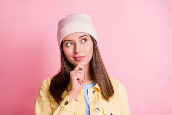 Photo of sweet shiny young lady wear casual outfit headwear looking empty space finger chin isolated pink color background — Stock Photo, Image