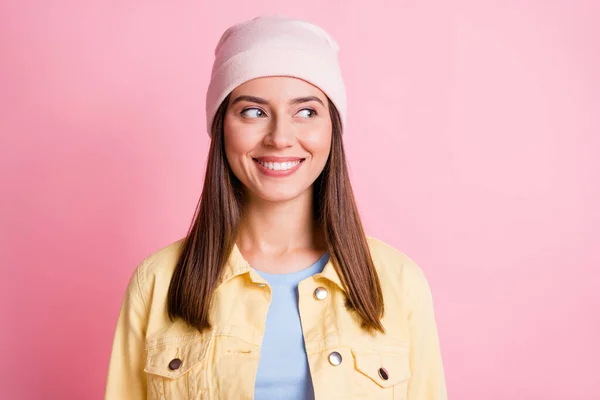 Foto di dolce brillante giovane donna vestita casual giallo vestiti berretto cercando spazio vuoto sorridente isolato colore rosa sfondo — Foto Stock