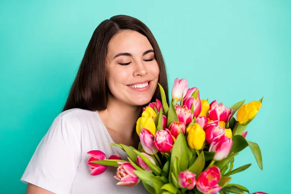 Fotografie mladé atraktivní ženy šťastný pozitivní úsměv těšit aroma jarní květiny tulipány izolované přes tyrkysové barvy pozadí — Stock fotografie