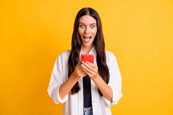 Photo of amazed young woman look hold phone read notification isolated on shine yellow color background — Stock Photo, Image