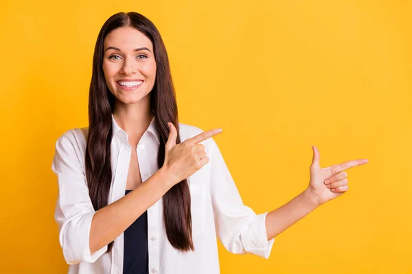 Photo of charming cheerful lady beaming smile indicate fingers empty space isolated on yellow color background — Stock Photo, Image