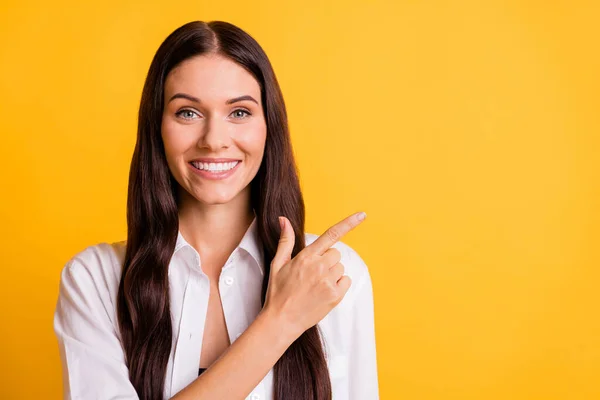 Photo of pretty cheerful lady point index finger empty space feedback isolated on yellow color background — Stock Photo, Image