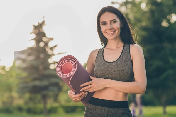 Porträt von charmanten positiven Mädchenarmen halten Teppich strahlend Lächeln Blick Kamera haben gute Laune Workout im Freien — Stockfoto