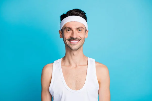 Portrait of positive sportive man look in camera wear white sport undershirt isolated over blue color background — Stock Photo, Image